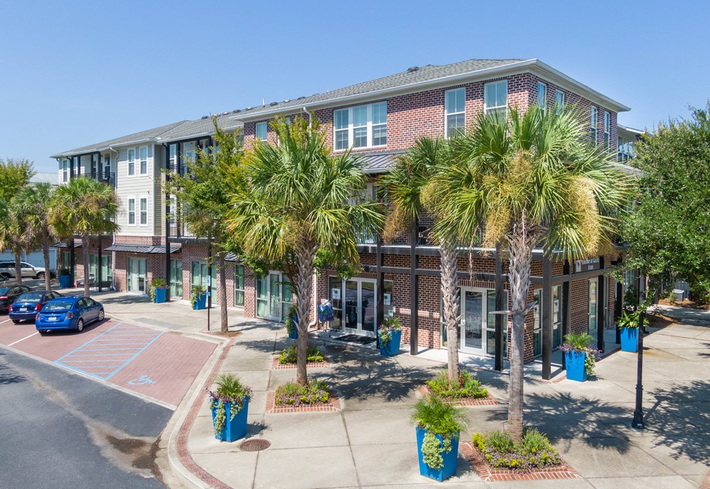 a building with palm trees in front of it on a city street