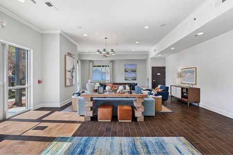 A living room with a blue couch and a rug.