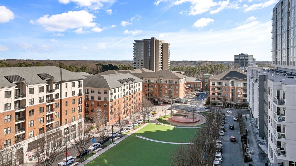 an aerial view of a city with buildings and a green park