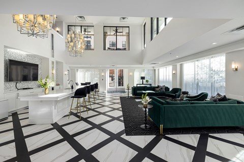 a living room with green couches and a white and black checkered floor
