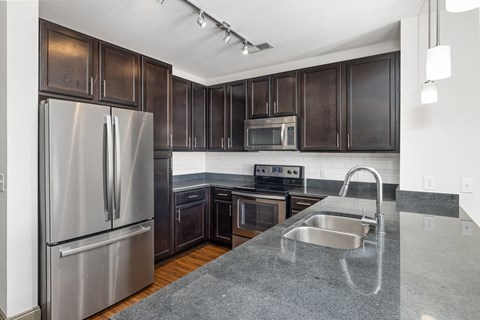 a kitchen with stainless steel appliances and dark wood cabinets