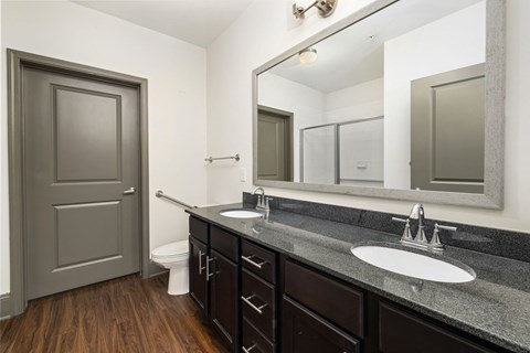 a bathroom with two sinks and a mirror and a toilet