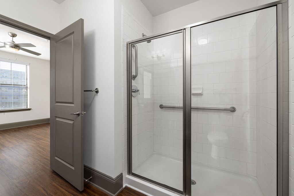 a white bathroom with a shower and a door