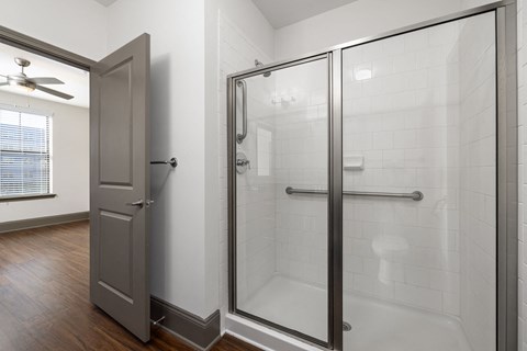 a white bathroom with a shower and a door