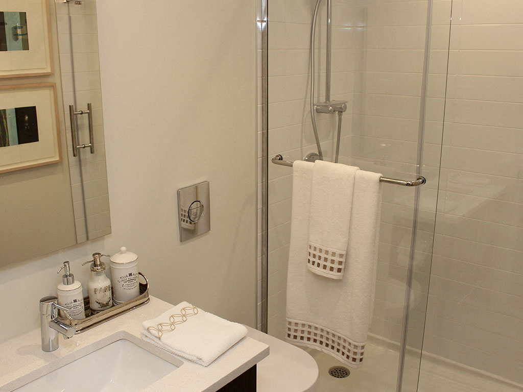 a bathroom with a shower and a sink and a towel