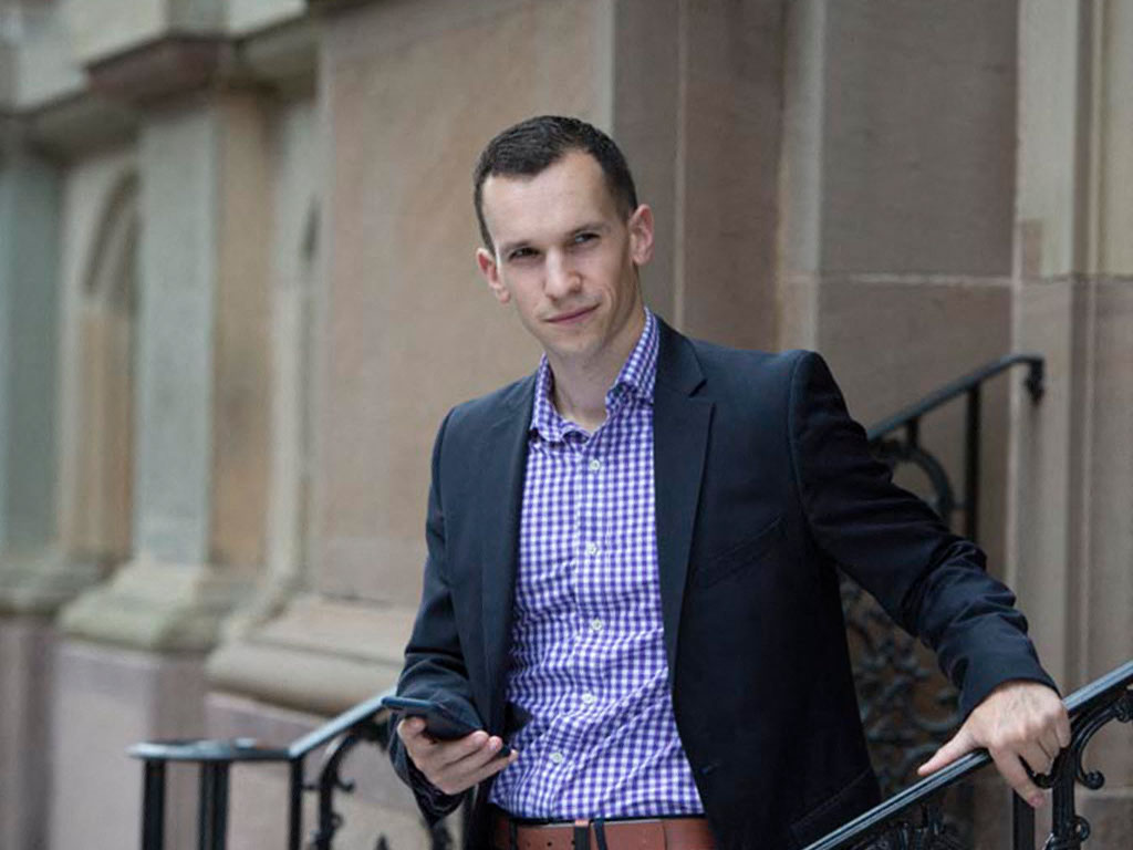 a man in a suit and tie holding a cell phone