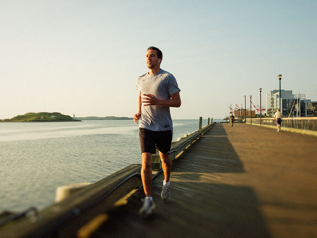 a man running on a pier near the water