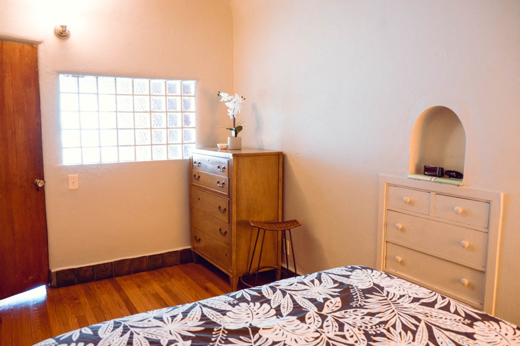 a bedroom with a bed and dresser and a window