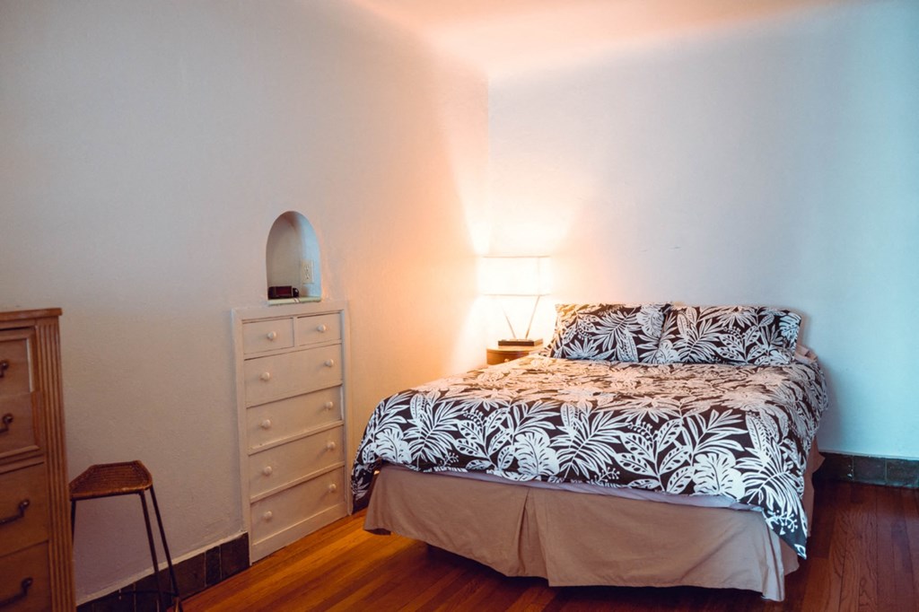 a small bedroom with a bed and a dresser