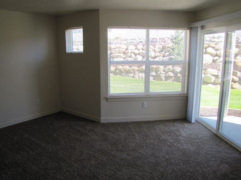 a living room with a large window and carpet