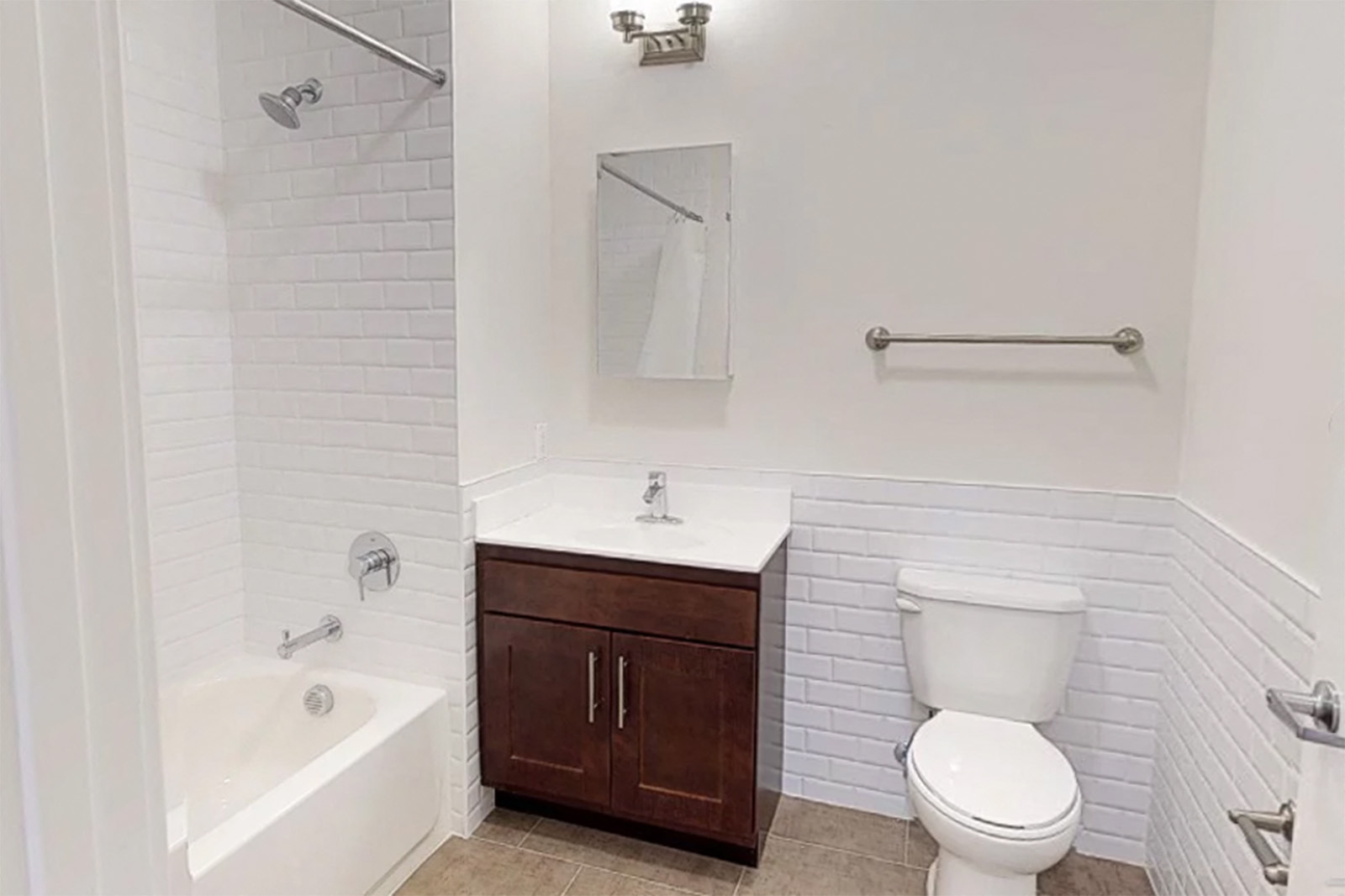 bathroom with wooden cabinet and white tiled walls &shower and beige tile floor