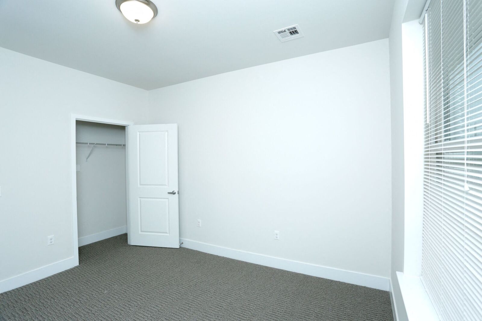 bedroom with white walls, carpeted floors and closet