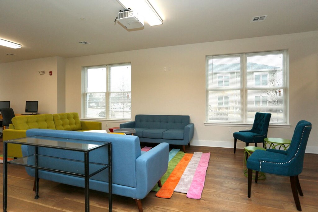 a living room with blue couches and chairs and a table