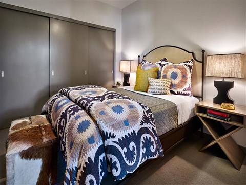 a bedroom with a bed and a nightstand with lamps