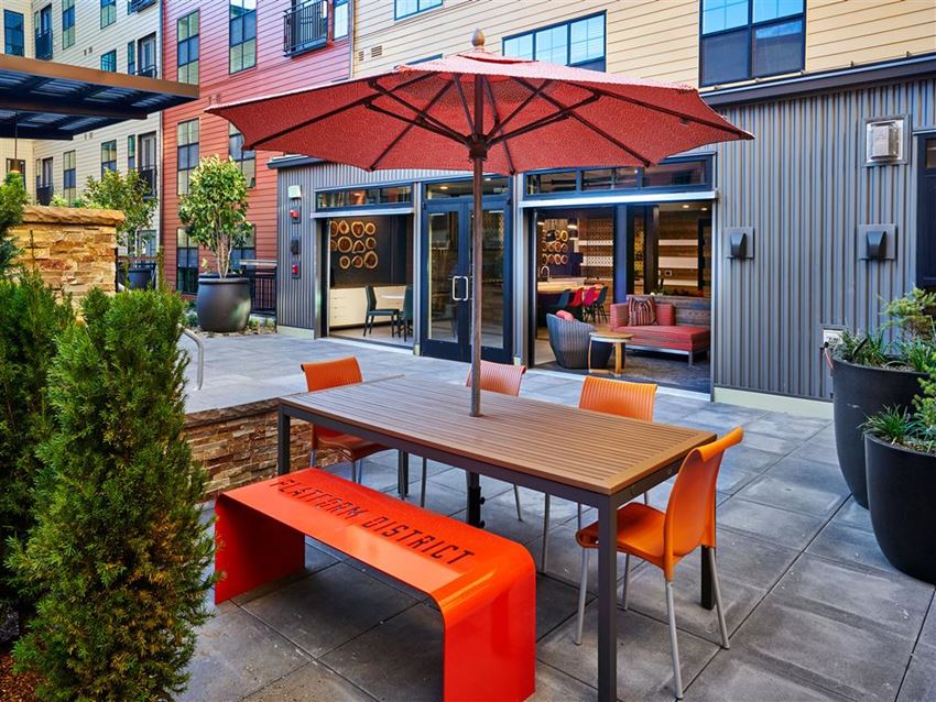 a picnic table with an umbrella and chairs on a patio