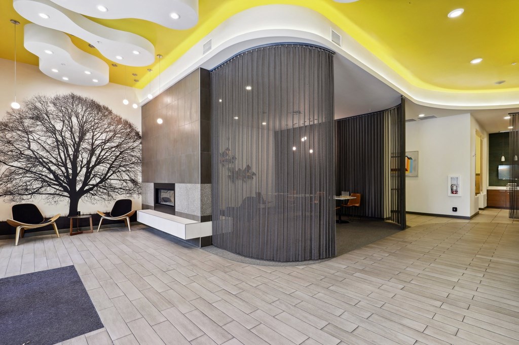 the lobby of a building with a yellow ceiling and a large door