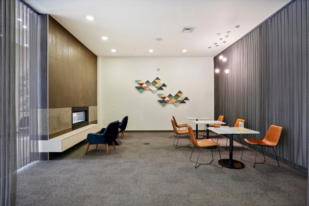 a conference room with a table and chairs and a wall with a clock