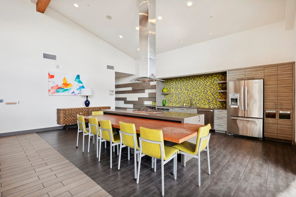 a large kitchen with a wooden table and yellow chairs
