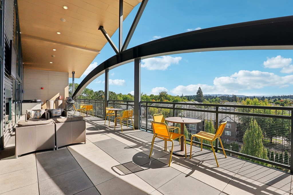a balcony with tables and chairs and a view of the city