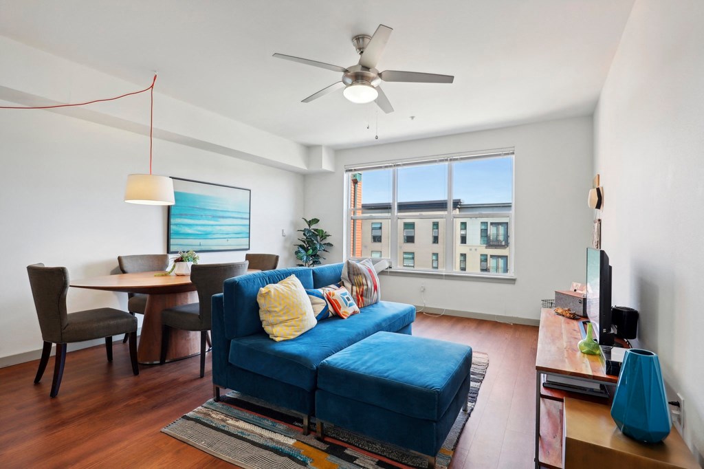 a living room with a blue couch and a ceiling fan