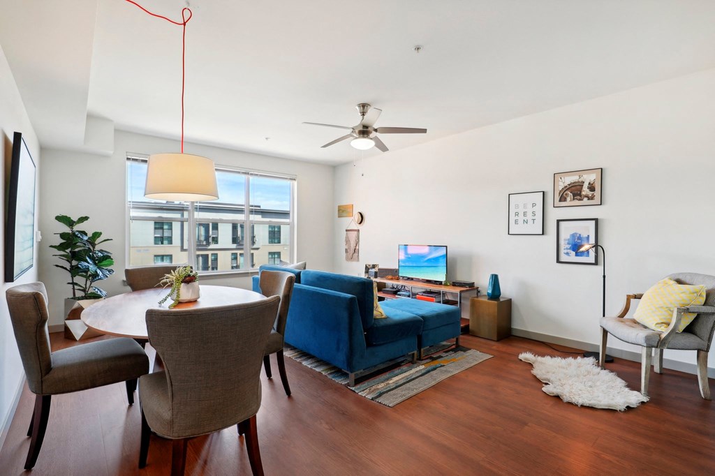 a living room with a couch and a table and a ceiling fan