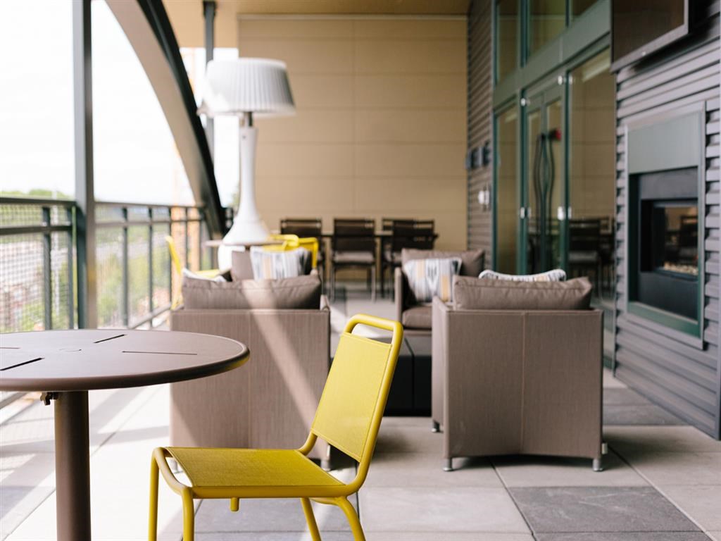 a living room with couches and a table with a yellow chair