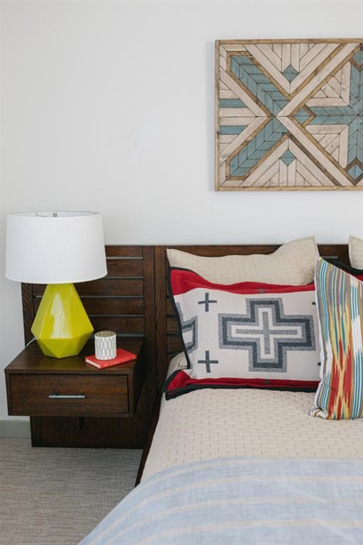 a bedroom with a bed and pillows and a painting on the wall