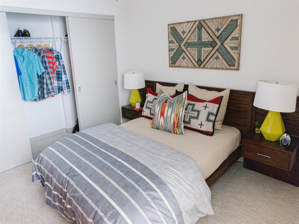 a bedroom with a bed with pillows and a closet