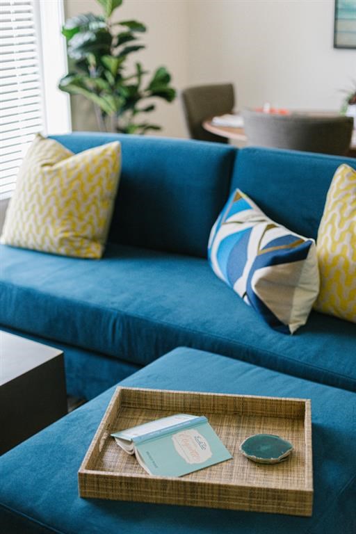 a living room with a blue couch and a wooden tray