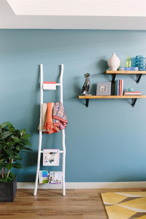 a white ladder against a blue wall with shelves