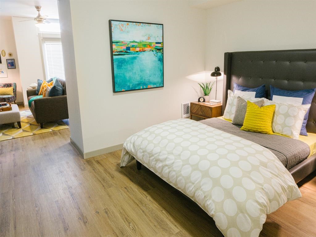 a bedroom with a bed and a painting on the wall