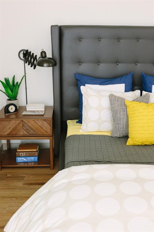 a bed with pillows and a nightstand with a lamp