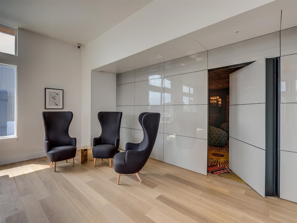 a living room with three chairs and a mirrored closet