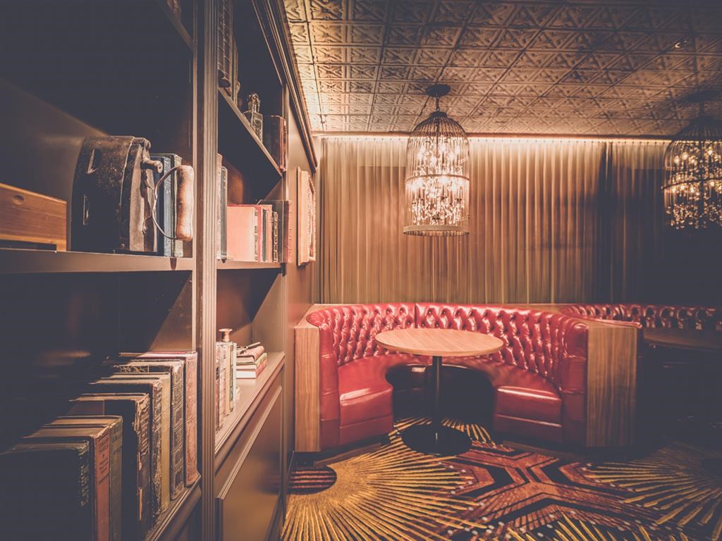 a small room with a red couch and a table