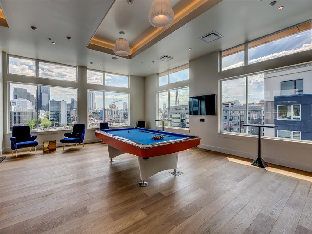 a games room with a pool table and a view of the city