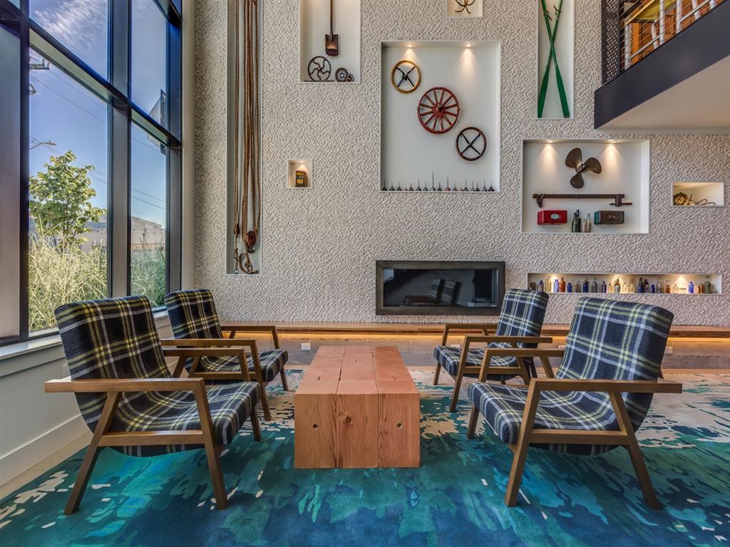 the lobby of a hotel with chairs and a fireplace