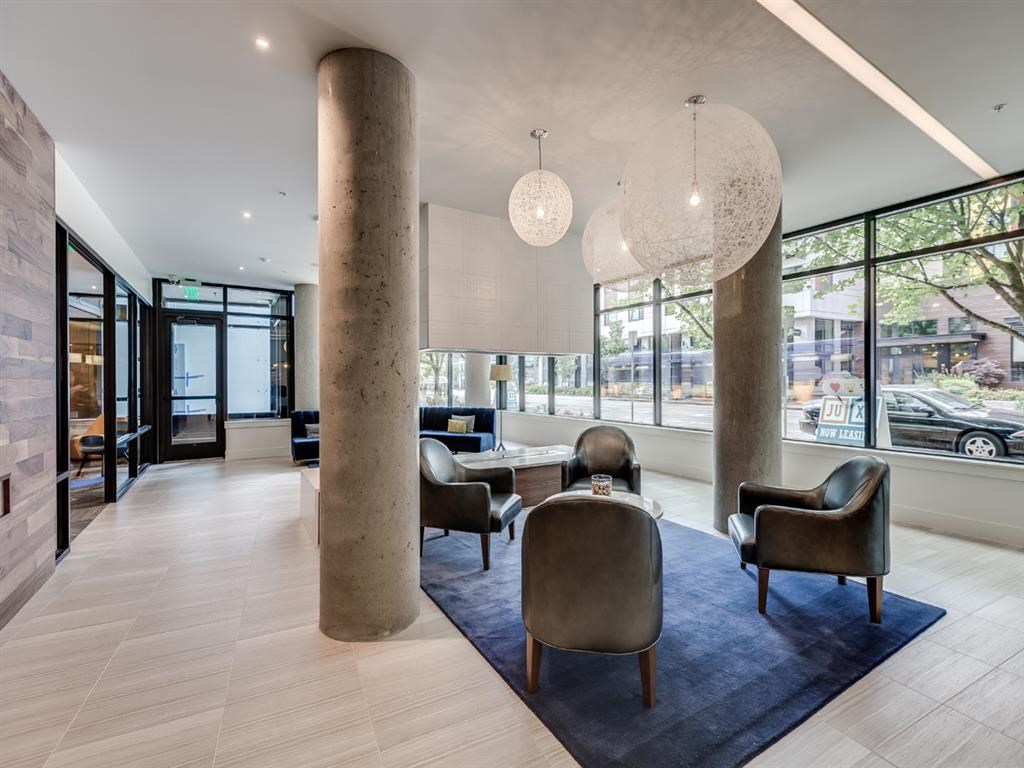a large lobby with chairs and tables and large windows