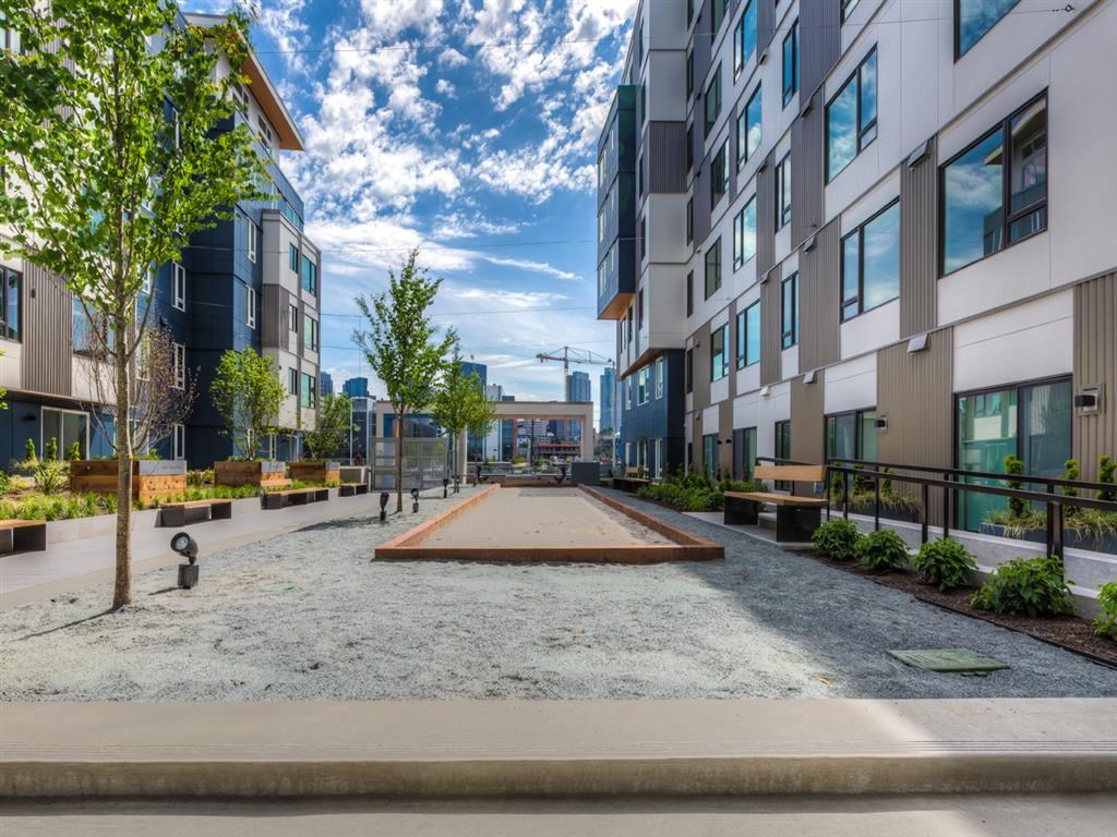 a courtyard between two modern buildings with trees and benches