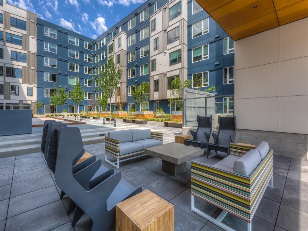 a rendering of a patio with chairs and tables in front of a building