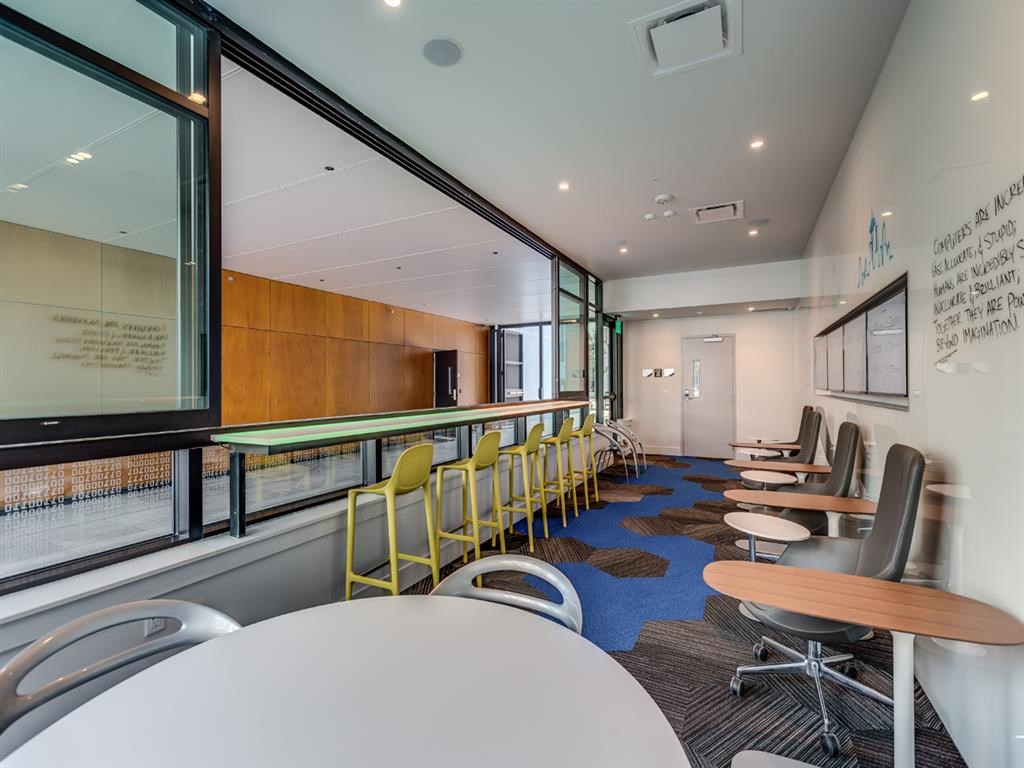 a room filled with tables and chairs and a large window