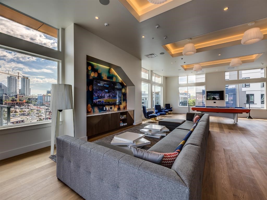 a large living room with a gray couch and a table
