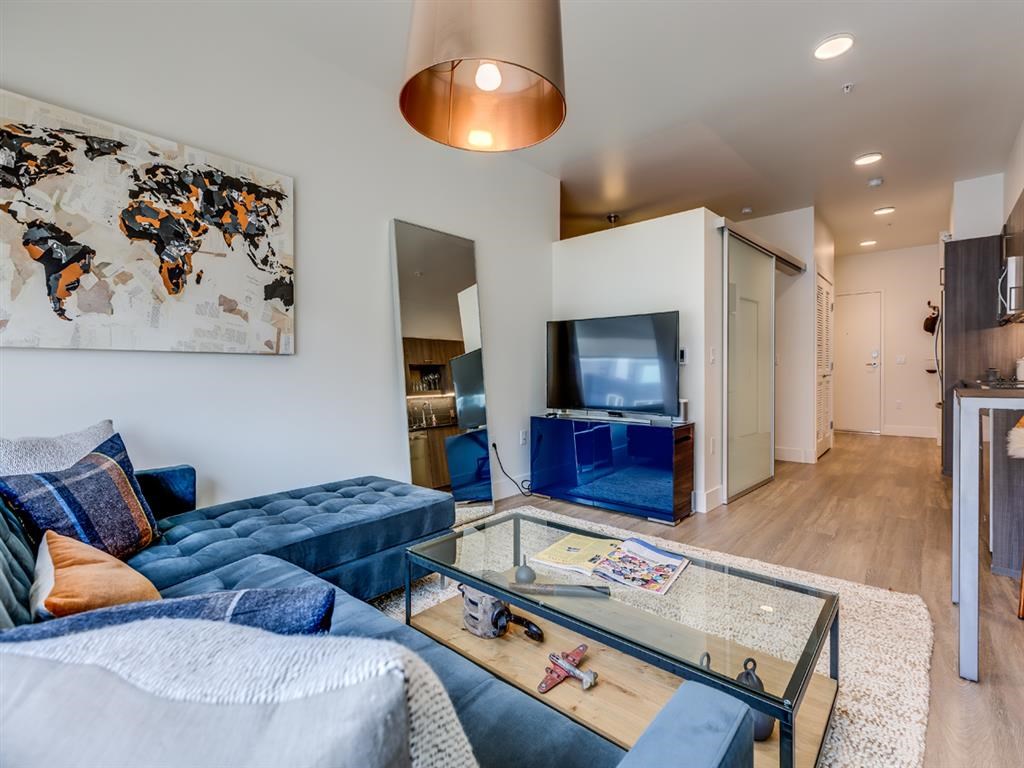 a living room with a blue couch and a glass table