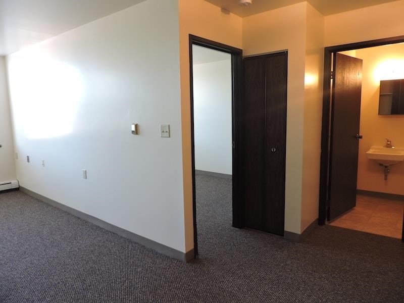 a room with two doors and a sink and a mirror