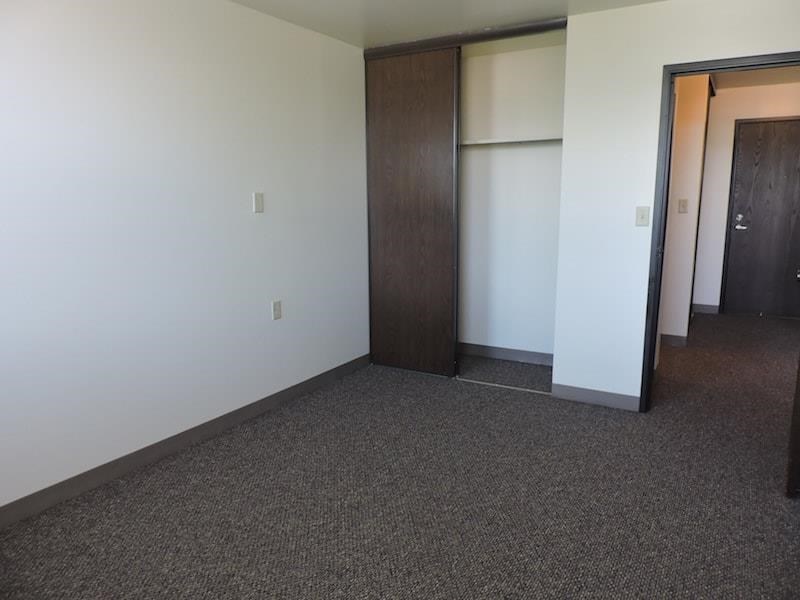 an empty living room with a door to a closet