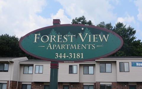 a sign for forest view apartments in front of a building