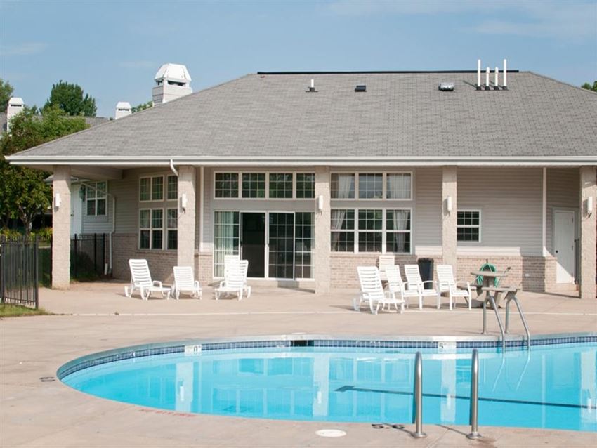 a swimming pool in front of a house with a pool
