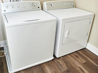 a washer and dryer are next to each other on a wood floor