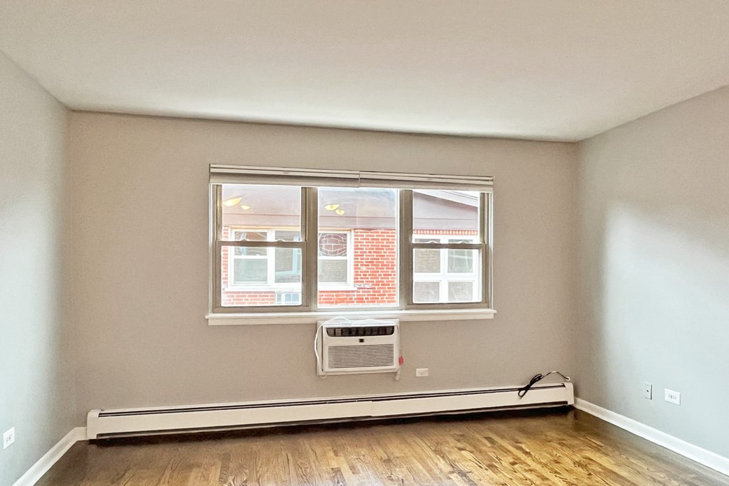 A room with a window and a radiator on the floor.