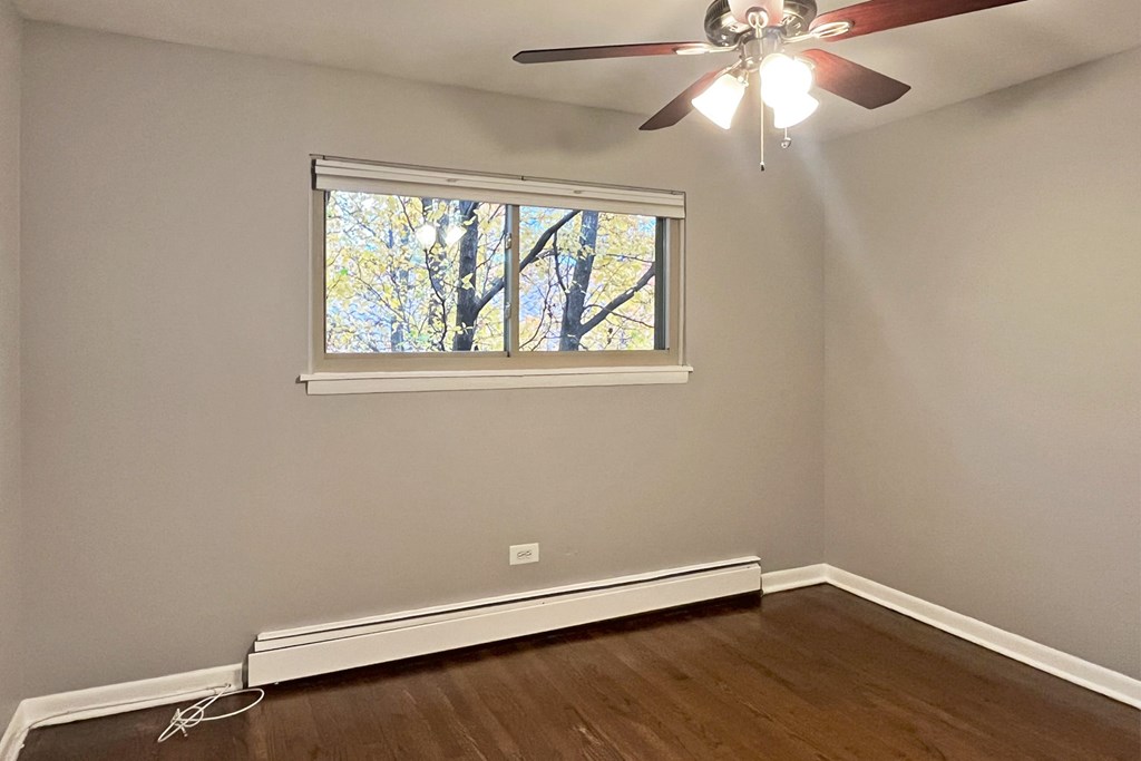 A room with a ceiling fan and a window.