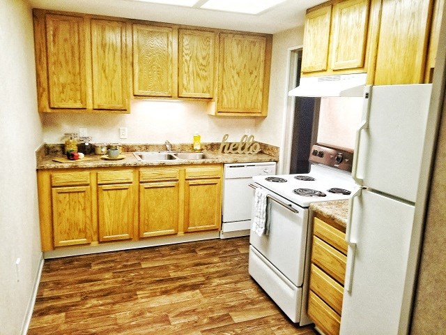 a small kitchen with a white stove and refrigerator